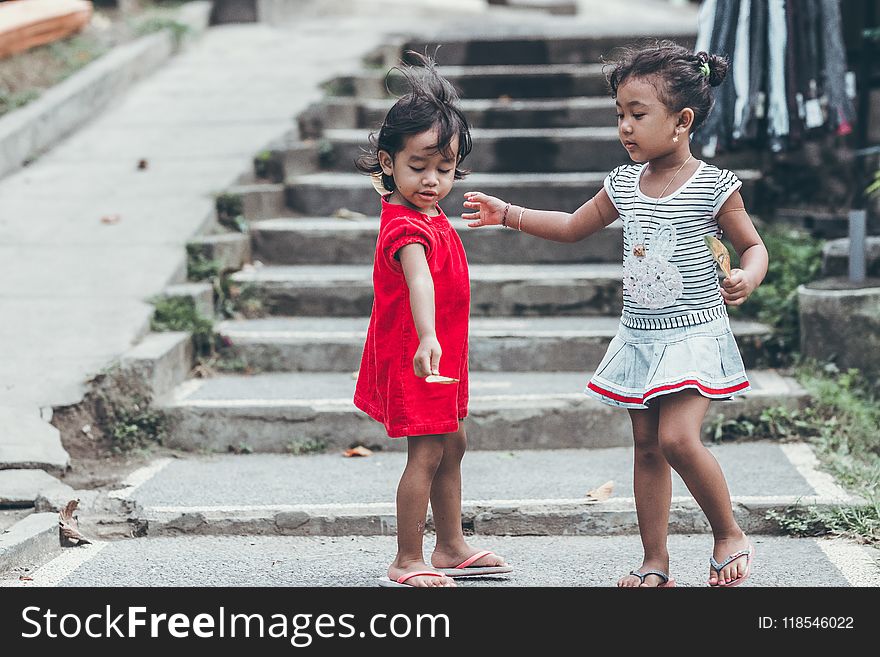 Two Toddler Wearing Red and Gray Dresses