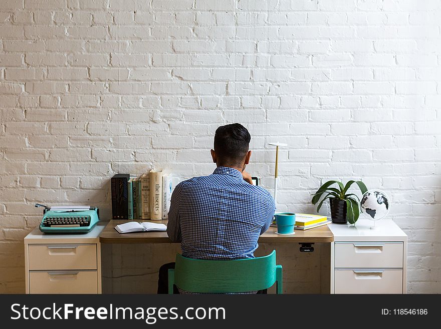 Man Sitting in Front of White Table