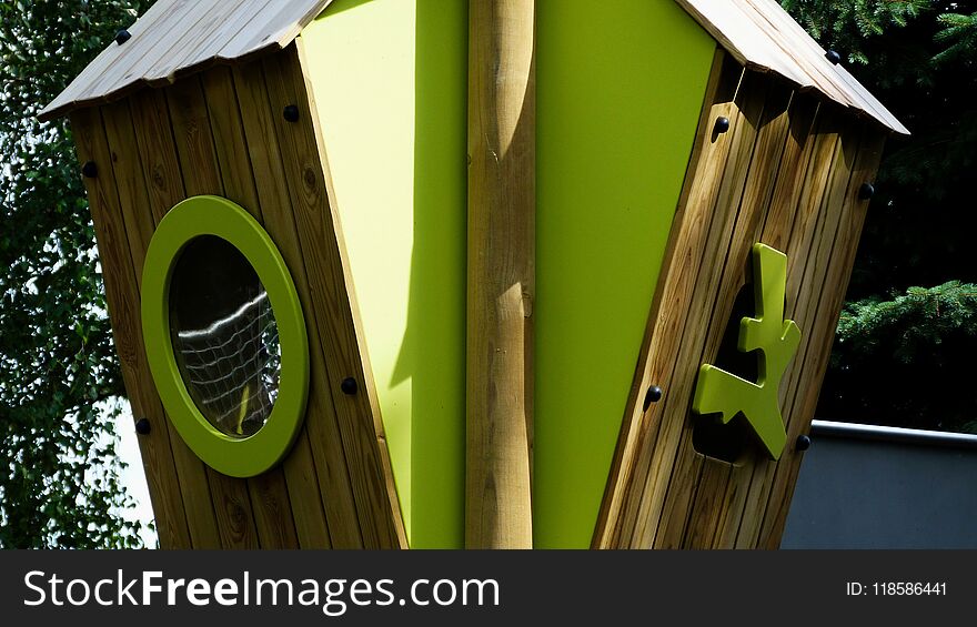 Wooden treehouse in playground with green plastic window and natural park surrounding in bright sunlight in the summer. Wooden treehouse in playground with green plastic window and natural park surrounding in bright sunlight in the summer