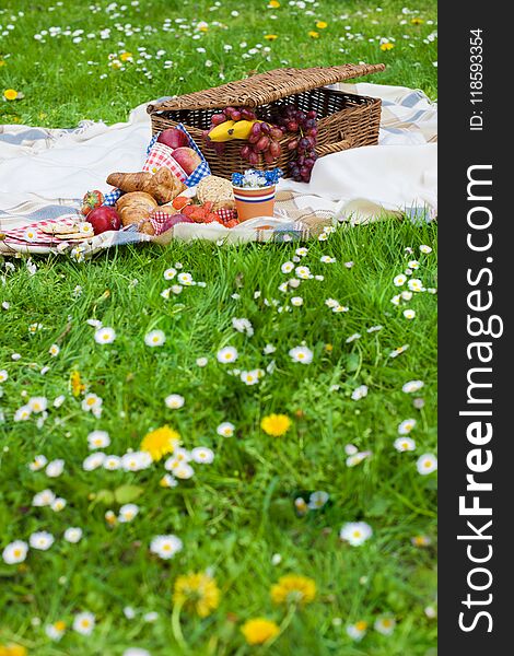 Picnic Basket And Food. Green Meadow With Flowers. Spring In The Netherlands.