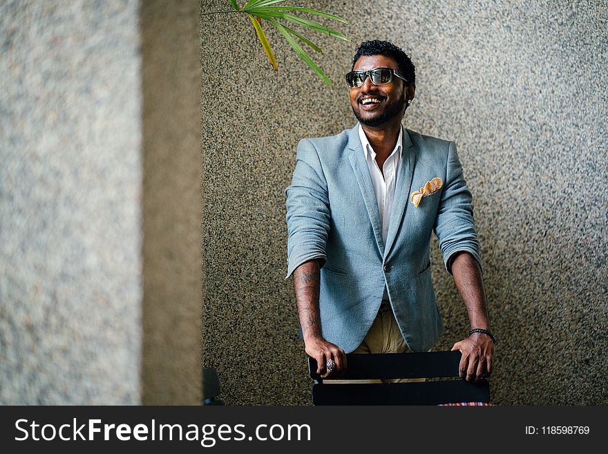 Man in Blue Formal Jacket in Front of Black Wooden Chair