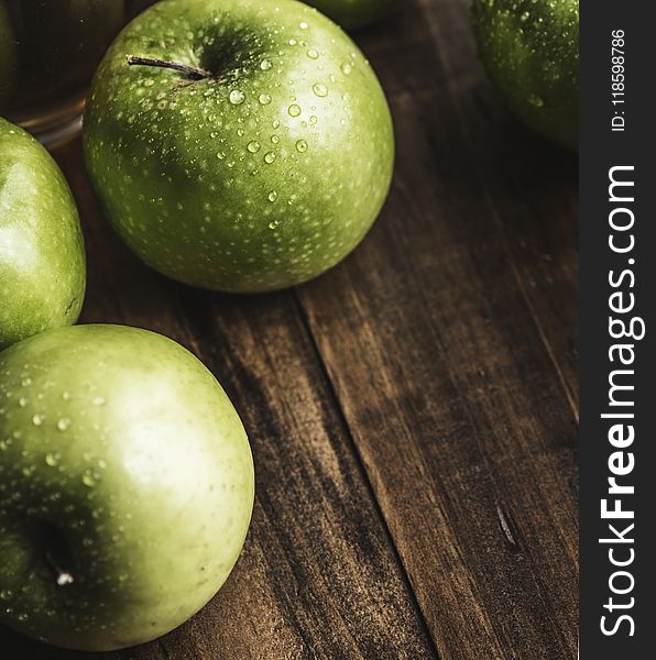 Green Apples on Brown Surface