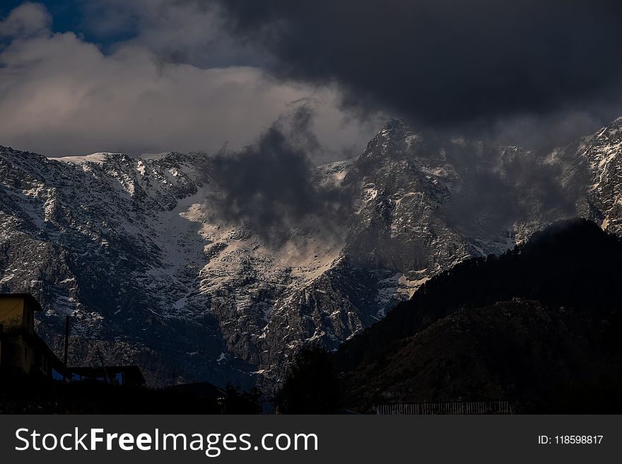 Snowy Mountain Peaks Under Cloudy Sky