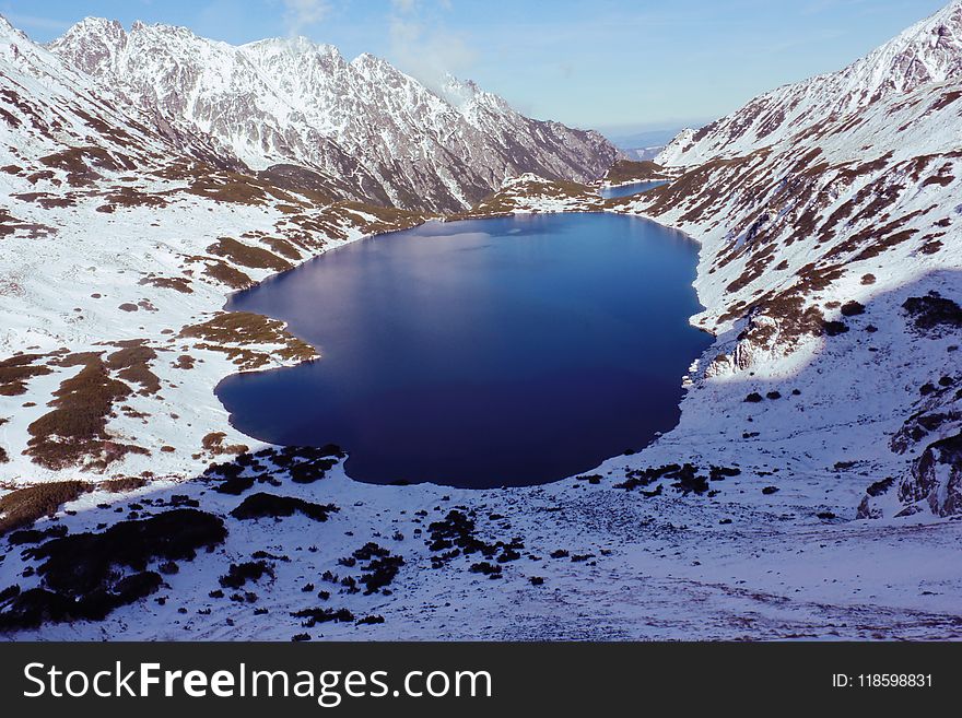 High-angle View of Body of Water in Between Snow-covered Mountain Range