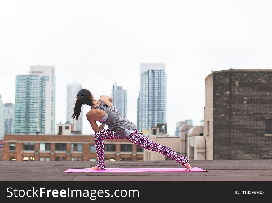 Woman Standing on Pink Yoga Mat Stretching