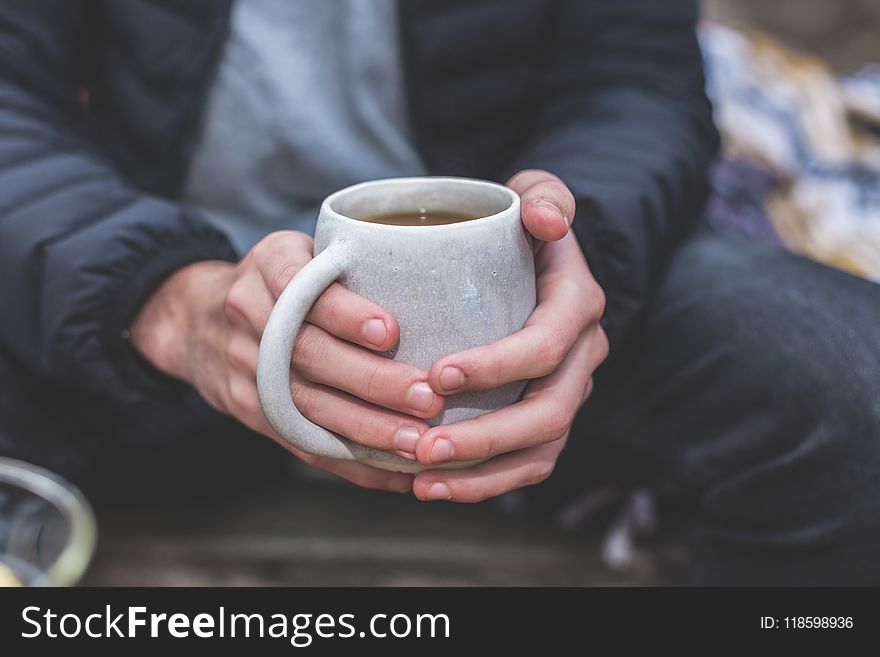 Shallow Focus Photography of a Person Holding White Ceramic Mug