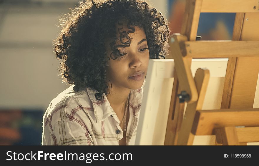 Woman Wearing White Collared Shirt Standing Near Brown Easel