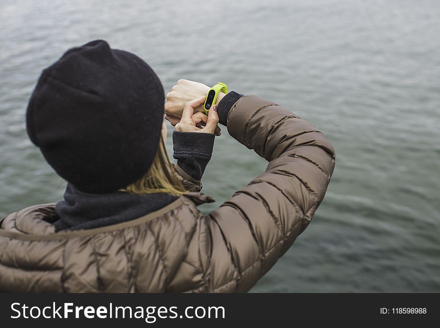 Woman Looking at Black and Yellow Activity Tracker
