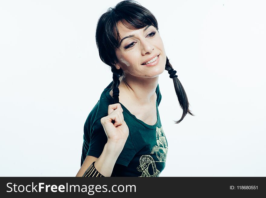 Young caucasian brunette with tail hair having fun in studio. White background, green shirt dressed. Copy space. Young caucasian brunette with tail hair having fun in studio. White background, green shirt dressed. Copy space