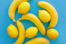 Yellow Bananas And Lemons On Bright Blue Paper, Trendy Flat Lay. Royalty Free Stock Image