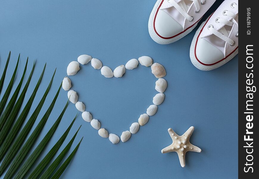 Shells, sea ster, sneakers and tropical leaf.