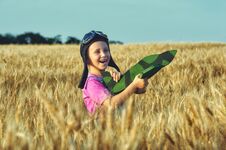 Cheerful Girl In A Field Of Wheat Playing With A Model Aircraft Royalty Free Stock Image