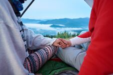 Close-up Of Guy And Girl Holding Hands Sitting In Tent On Blurred Background Mountains Stock Image