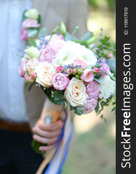 Closeup nice bouquet of flowers in fiancee and groom hands.