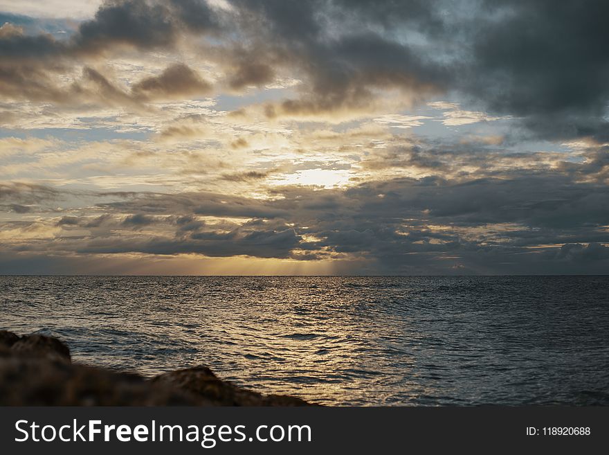 Sea Under Gray Cloudy Sky during Dawn