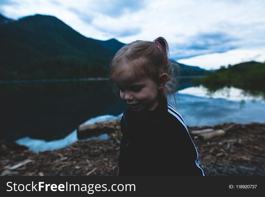 Girl Wearing Black and White Track Jacket Near Body of Water