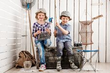 Two Little Children Sitting On Chest With Net And Rod In Hands Royalty Free Stock Photos