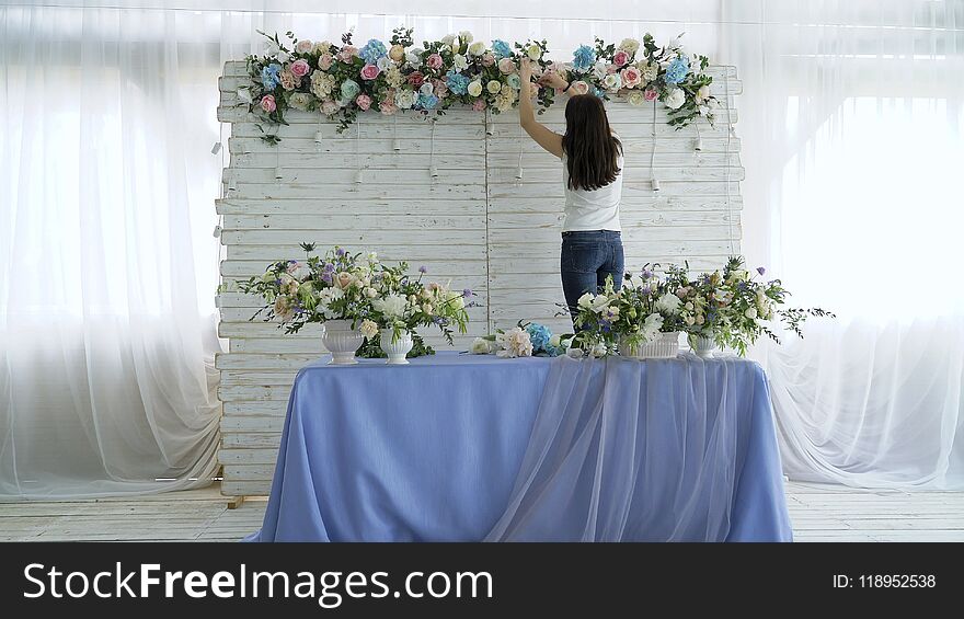 Beautiful florist creating spring colorful bouquet arrangement. Flowers event wedding decoration. Process of preparing floral composition for celebrating party.