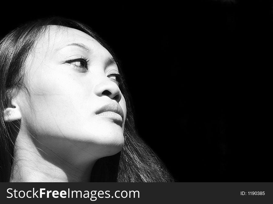 Black and white portrait of a asian young woman with black hair in front of black background. Black and white portrait of a asian young woman with black hair in front of black background
