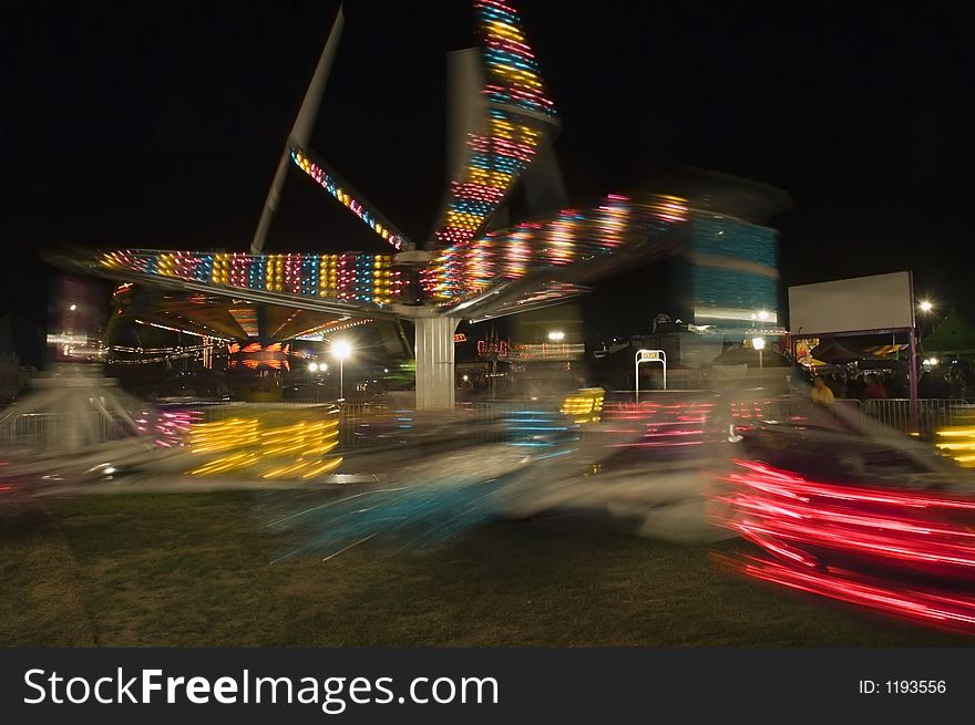 Fair ride spins around and makes light patterns - motion blur due to long exposure. Fair ride spins around and makes light patterns - motion blur due to long exposure