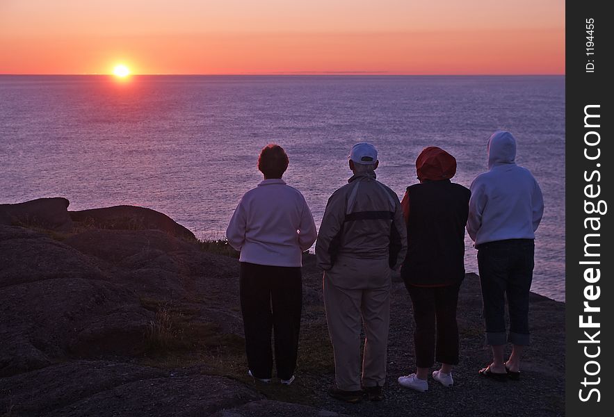 A group of tourists enjoying a coastal sunrise