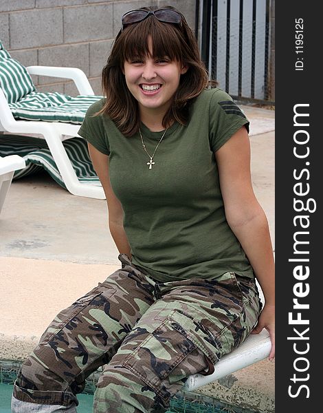 Girl sitting on a diving board with a big smile. Girl sitting on a diving board with a big smile.