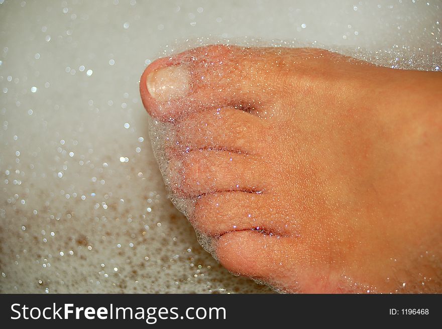 Womens feet in bath with droplets. Womens feet in bath with droplets