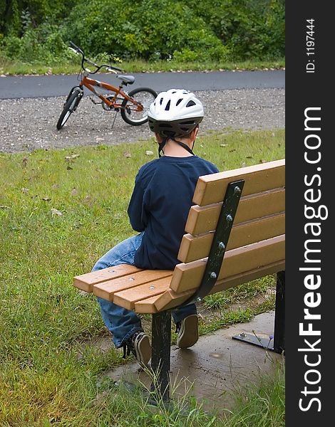 Boy on Bench Resting from Cycling. Boy on Bench Resting from Cycling