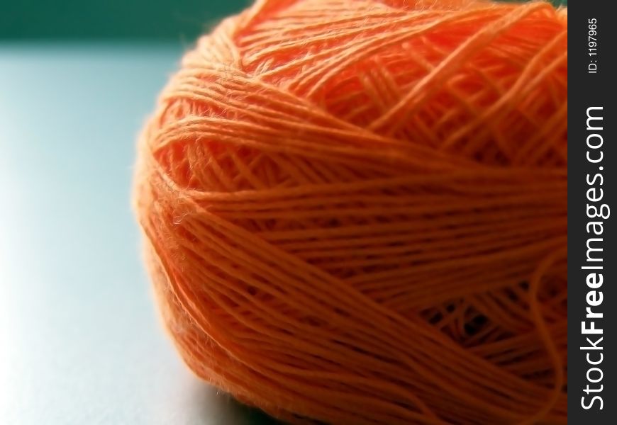 Ball of orange yarn used for sewing.
