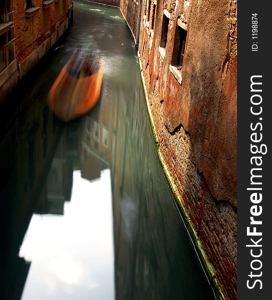 A boat ghosts along the canal in Venice. A boat ghosts along the canal in Venice.