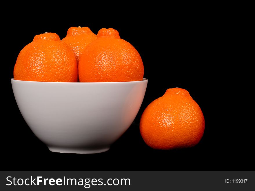 Three Minneola Oranges In White Bowl With One Orange At Side