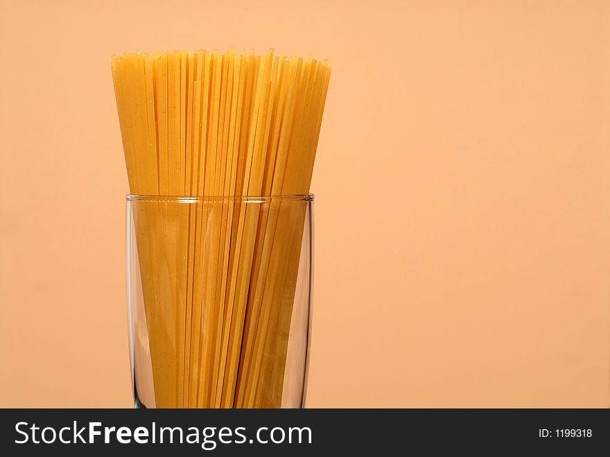 Spaghetti in clear glass with wheat colored background