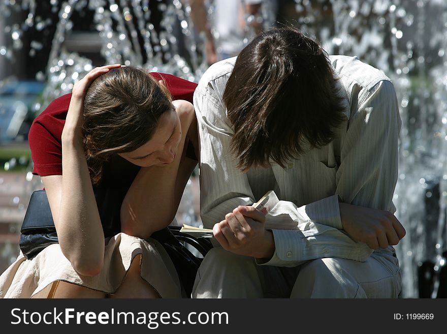 The young man and the girl read the book in the street. The young man and the girl read the book in the street