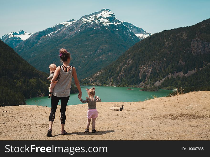 Mother And Children Walks Near Body Of Water