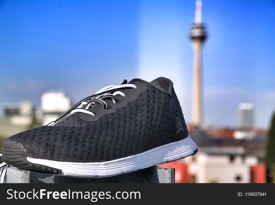 Unpaired of Black and White Lace-up Sneaker in Selective Focus Photography