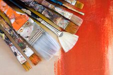 Various Old Paint Brushes On An Abstract Painting Stock Photo