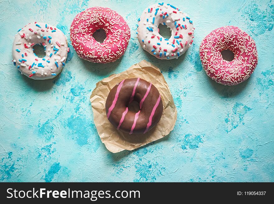 Colorful Donuts On Blue Stone Table. Top View.