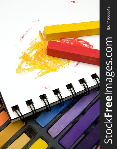 Vertical Image of Colorful Pastel Crayons and Coloring Book