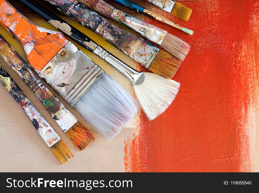 Various Old Paint Brushes on an Abstract Painting Horizontal