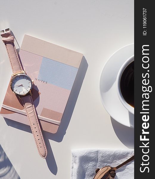 Round Gold-colored Analog Watch With Pink Leather Strap on Pink Notebook