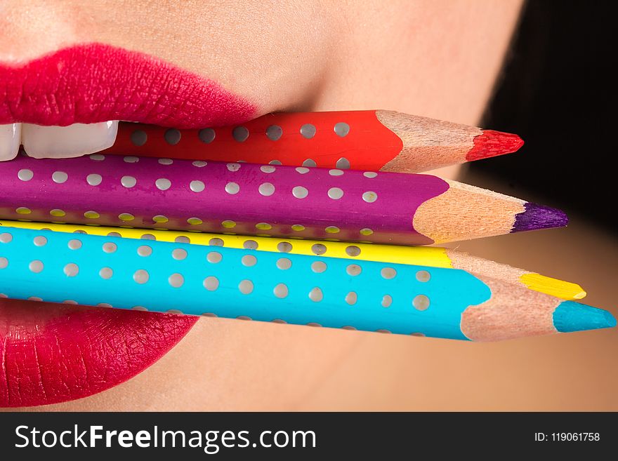 Woman Biting Three Color Pencils