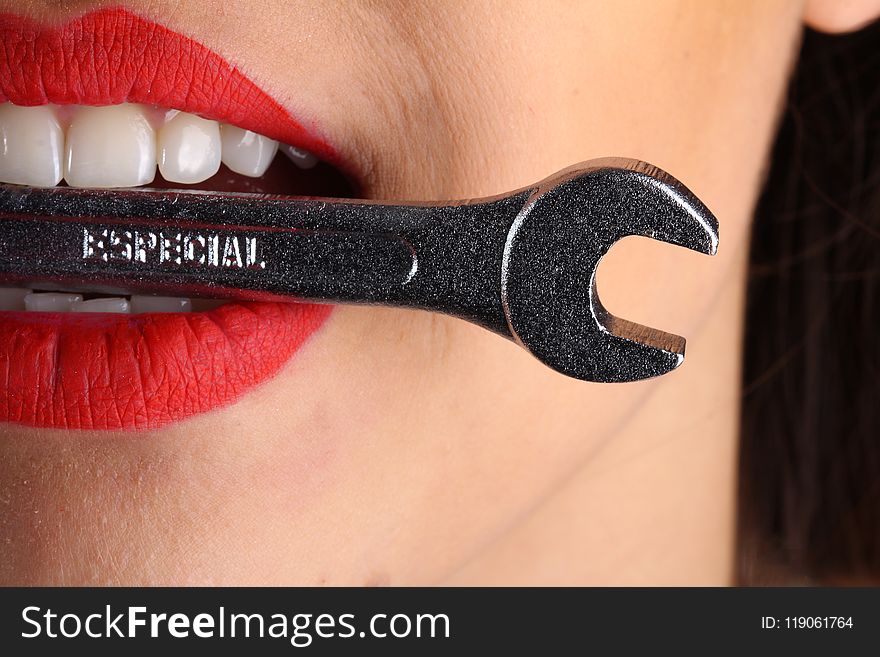 Close View Of Woman With Red Lips Biting Gray Special Wrench