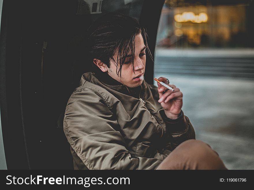 Man Wearing Gray Jacket Holding Cigarette