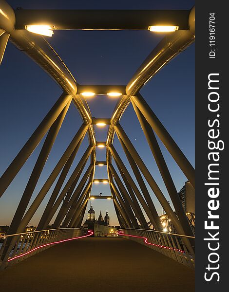 Two Red Light Trails From Two Bicycles On A Modern Bridge