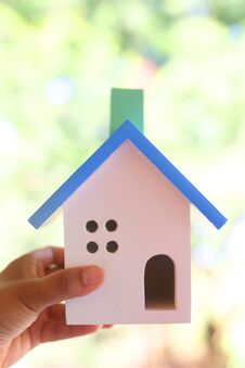 Hand Holding Wooden Toy House Made From Many Pieces Stock Photo