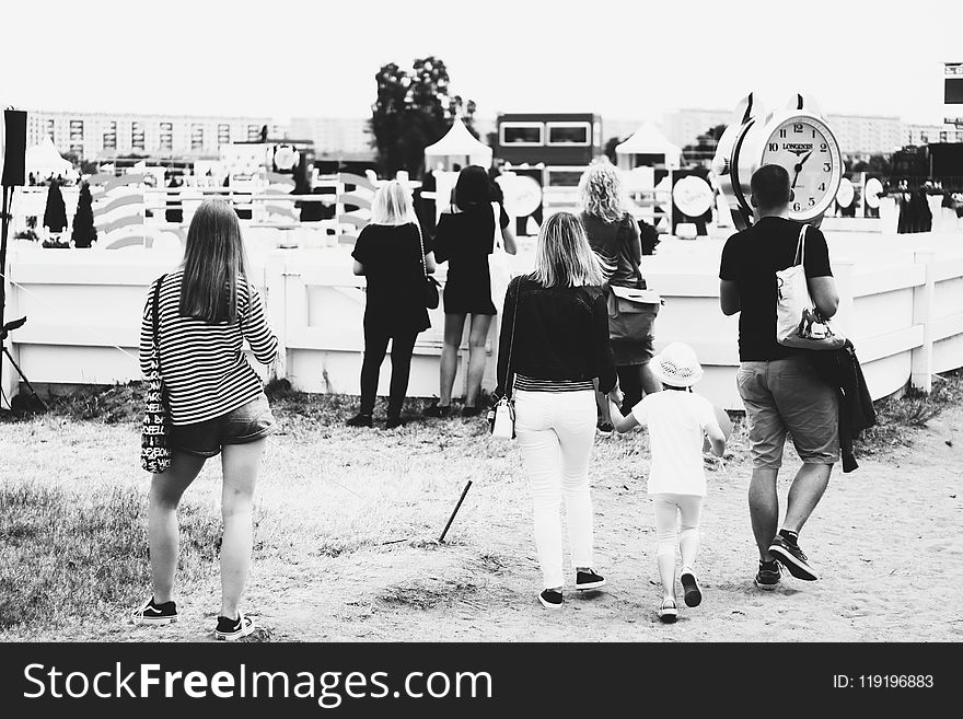 Grayscale Photo Of People Gathering Near Clock