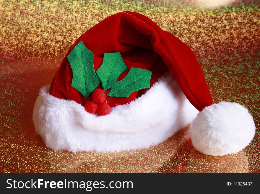 Santa Claus Hat with holly leaves gold back round. Santa Claus Hat with holly leaves gold back round