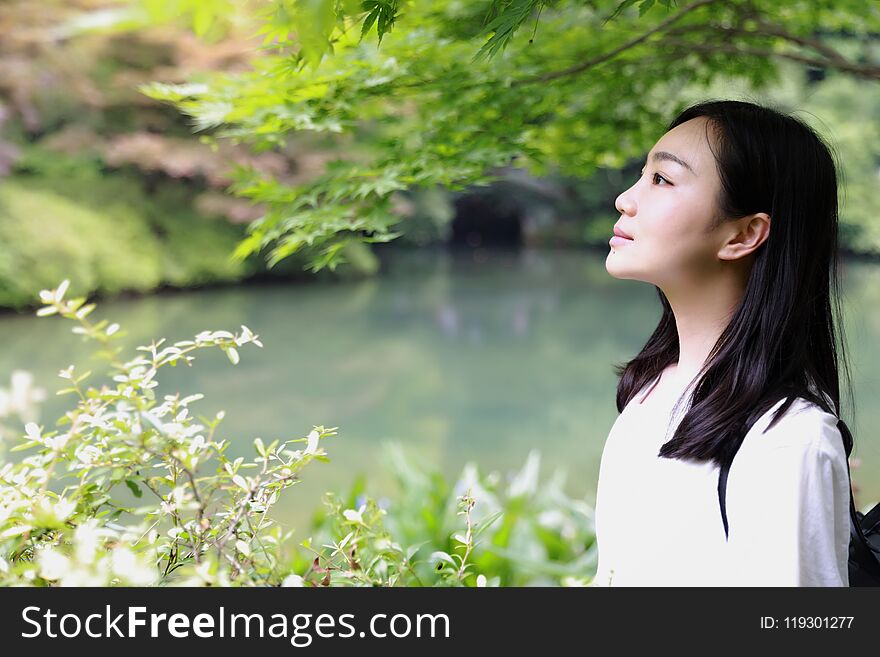 A happy free smile peace balance meditation beauty girl Asian Chinese travel hiking smell maple do yoga by lake bag hangzhou xihu