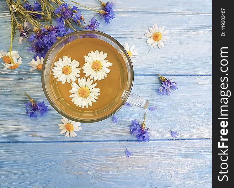 Chamomile tea cornflower on a wooden background summer morning. Chamomile tea cornflower on a wooden background summer morning