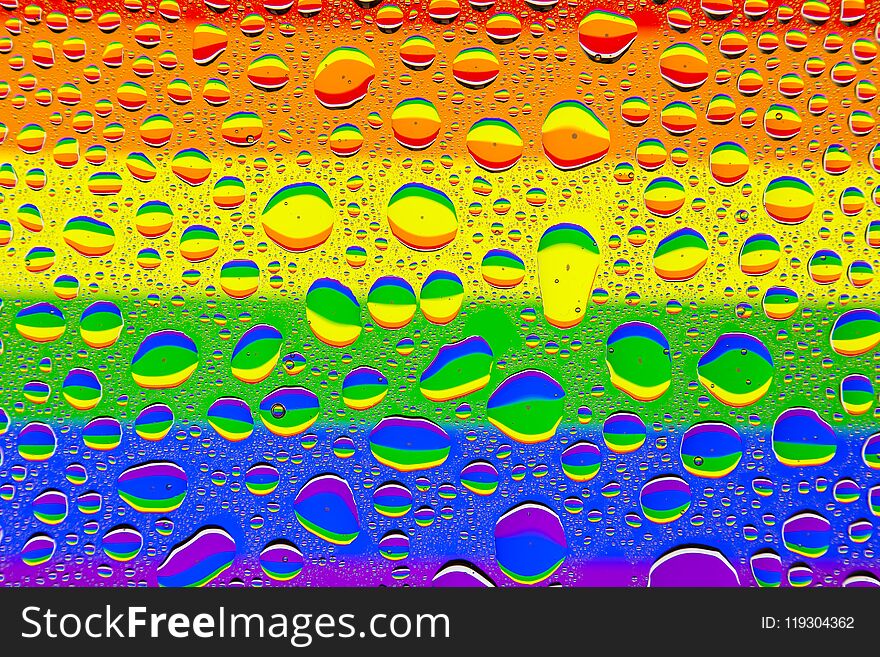 Close up of a water drops on a multicolored rainbow gradient background, covered with drops of water -condensation.